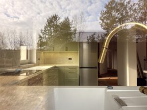 Piękne kuchnia w połączeniu kolorów bieli, trawy cytrynowej, akcentowana pozłacanymi okuciami oraz czernią